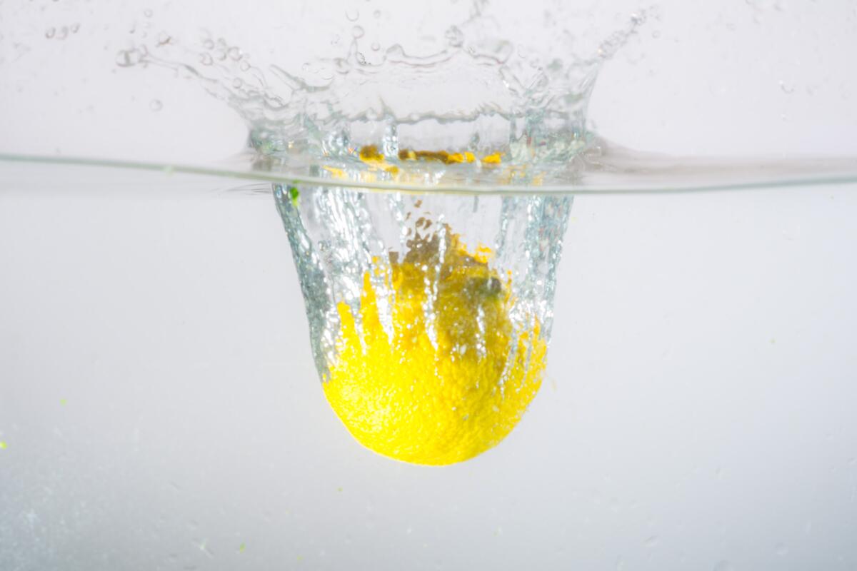 Желтый лимон упал в воду