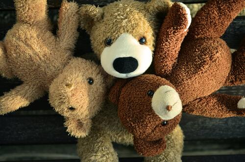 Three teddy bears lying in the group