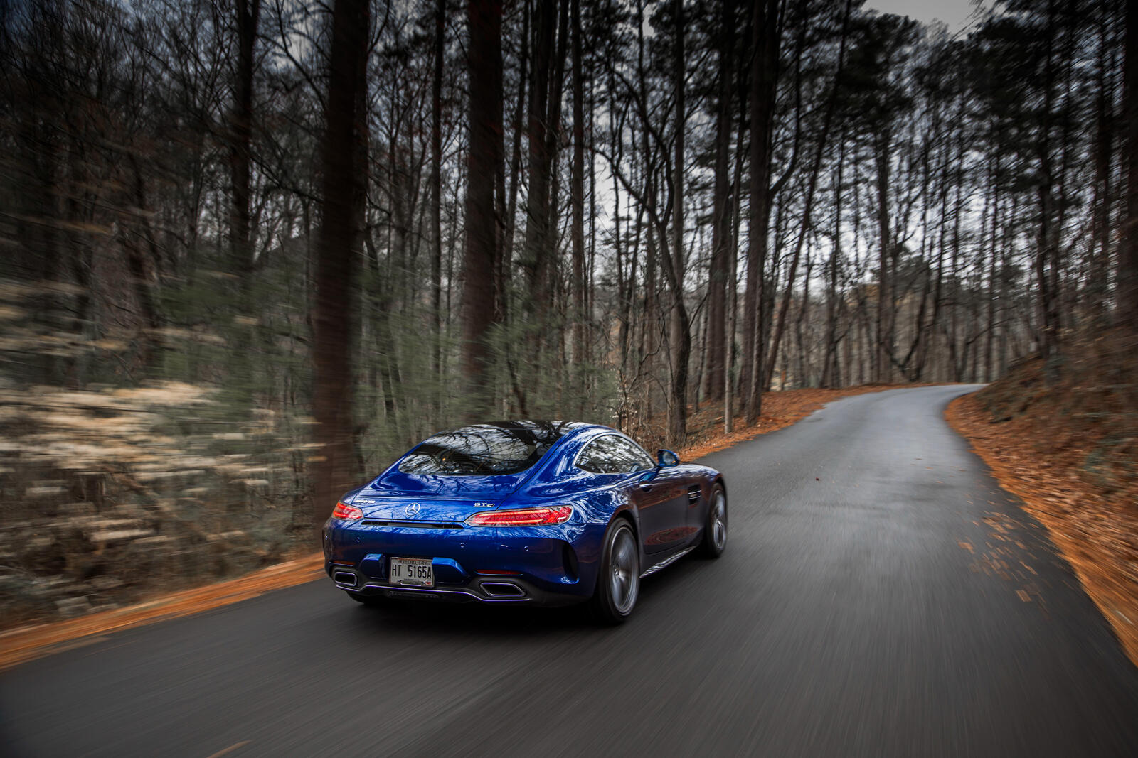 Free photo A blue Mercedes amg gtc in an autumn forest.