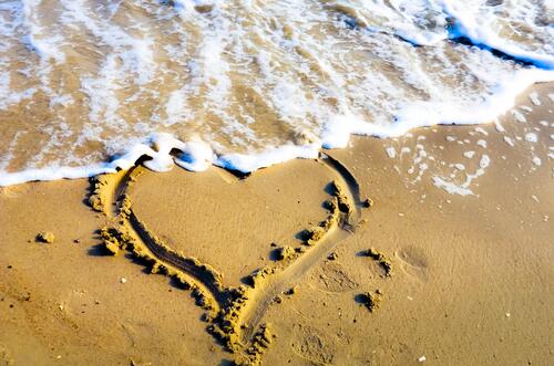 Сердечко нарисованное на берегу песочного пляжа