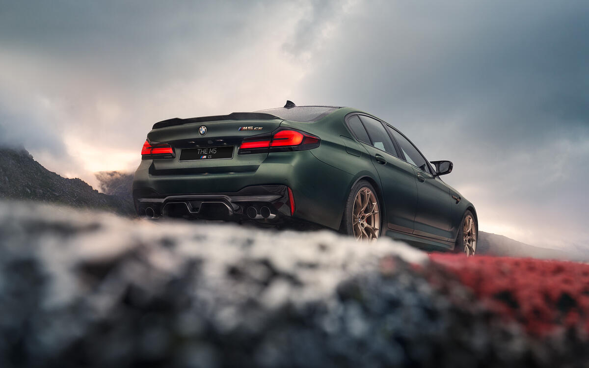 Green BMW M5 F90 Competition rear view with lights on