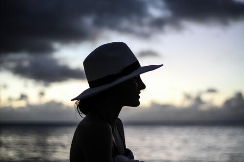 A silhouette of a girl in a hat