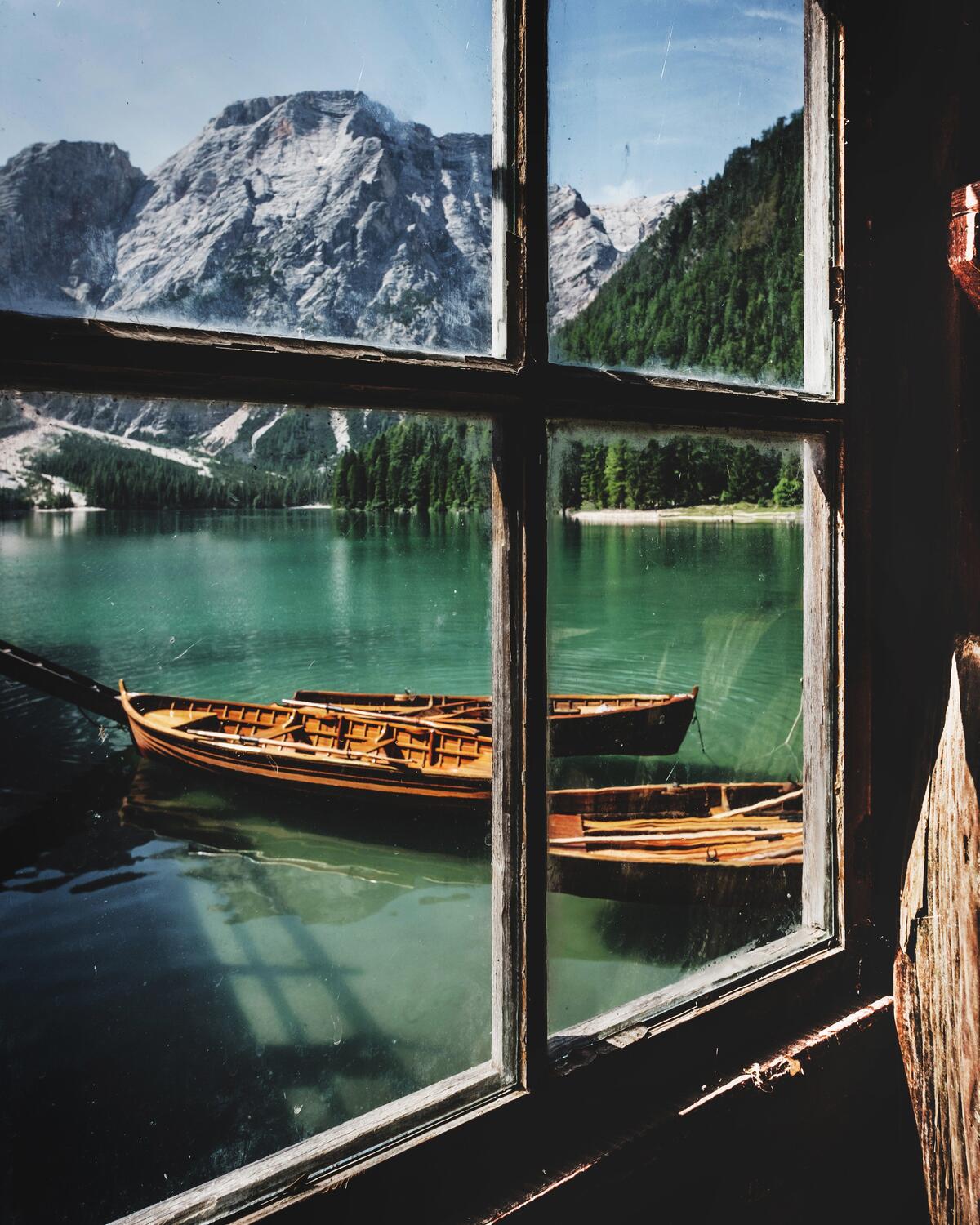 Захватывающий вид из окна рыбацкого домика с видом на озеро с лодками