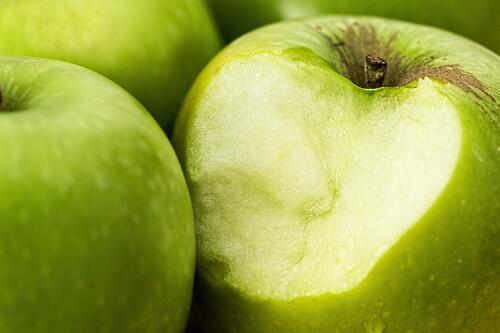 Откусанное зеленое яблоко