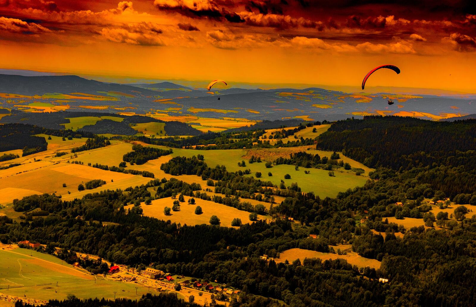Бесплатное фото Летим на параплане над полями во время восхода солнца