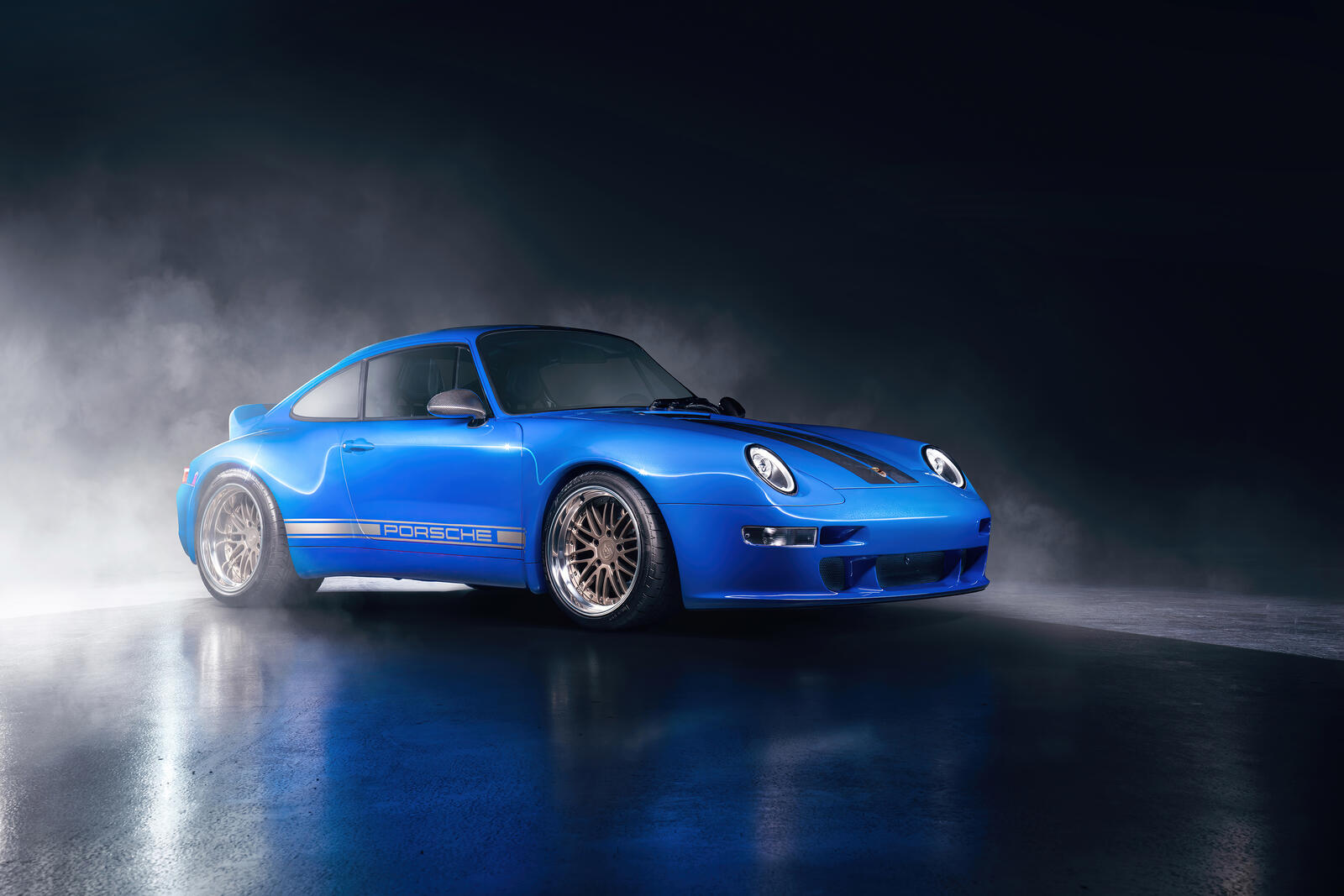 Free photo Blue Porsche 911 in a dark room illuminated by light