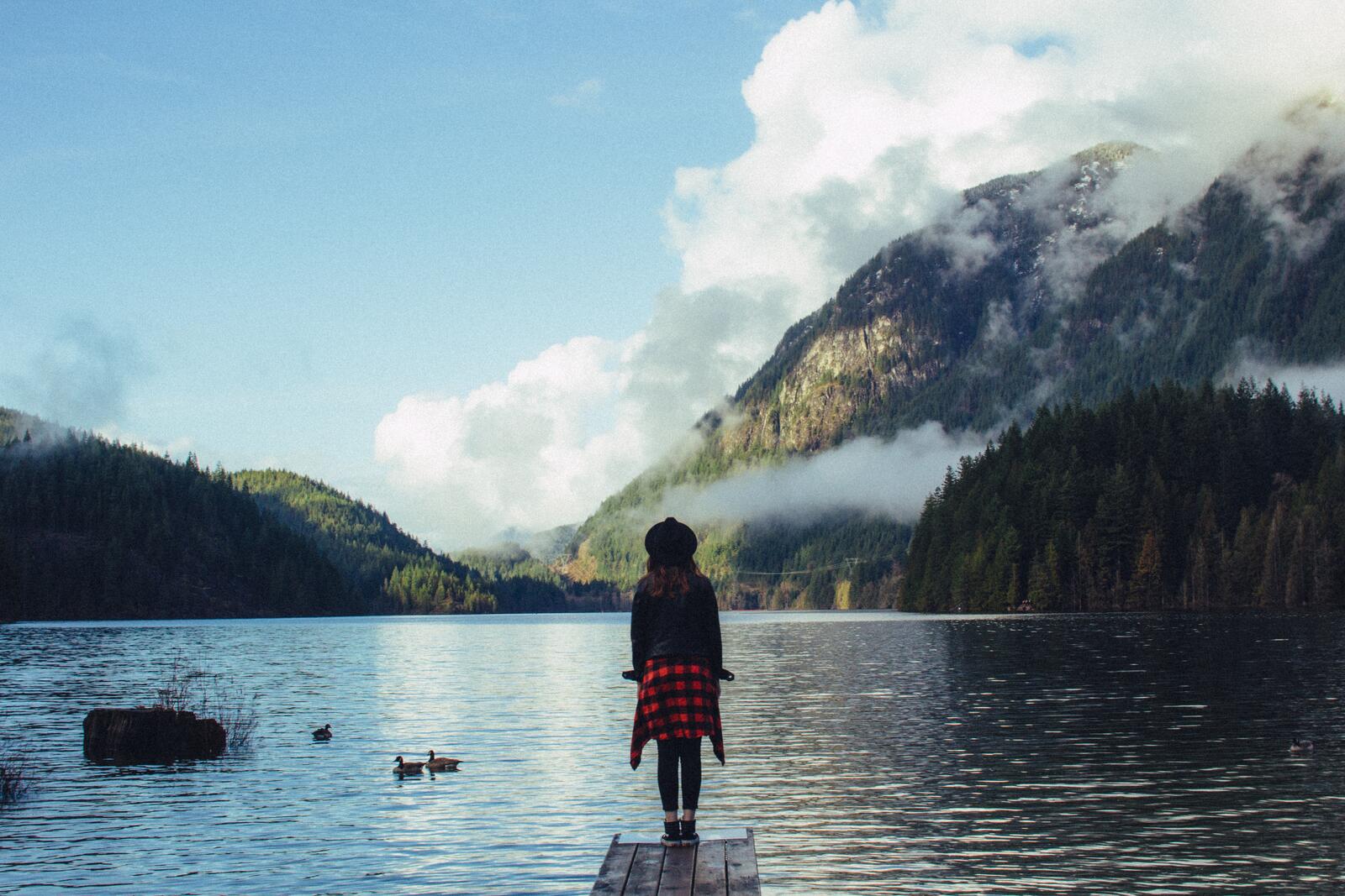 Бесплатное фото Девочка стоит на мостике у озера