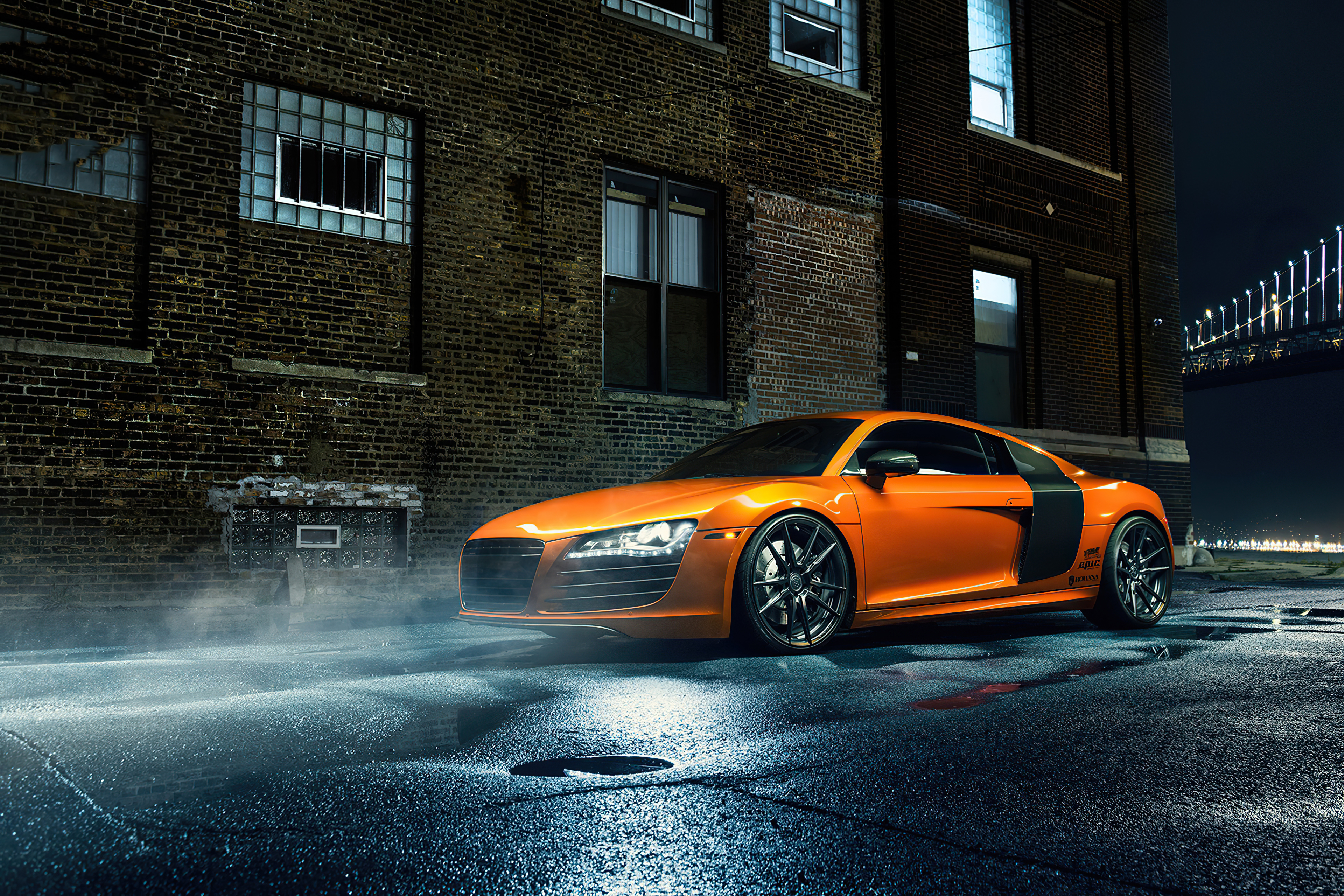 Оранжевая Audi R8 стоит на мокрой ночной дороге
