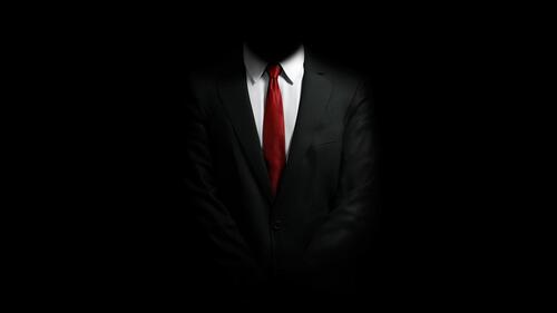 Строгий мужской костюм с красным галстуком на черном фоне