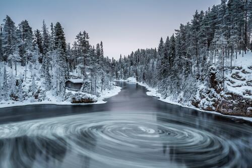 A whirlpool in a lake with snow banks
