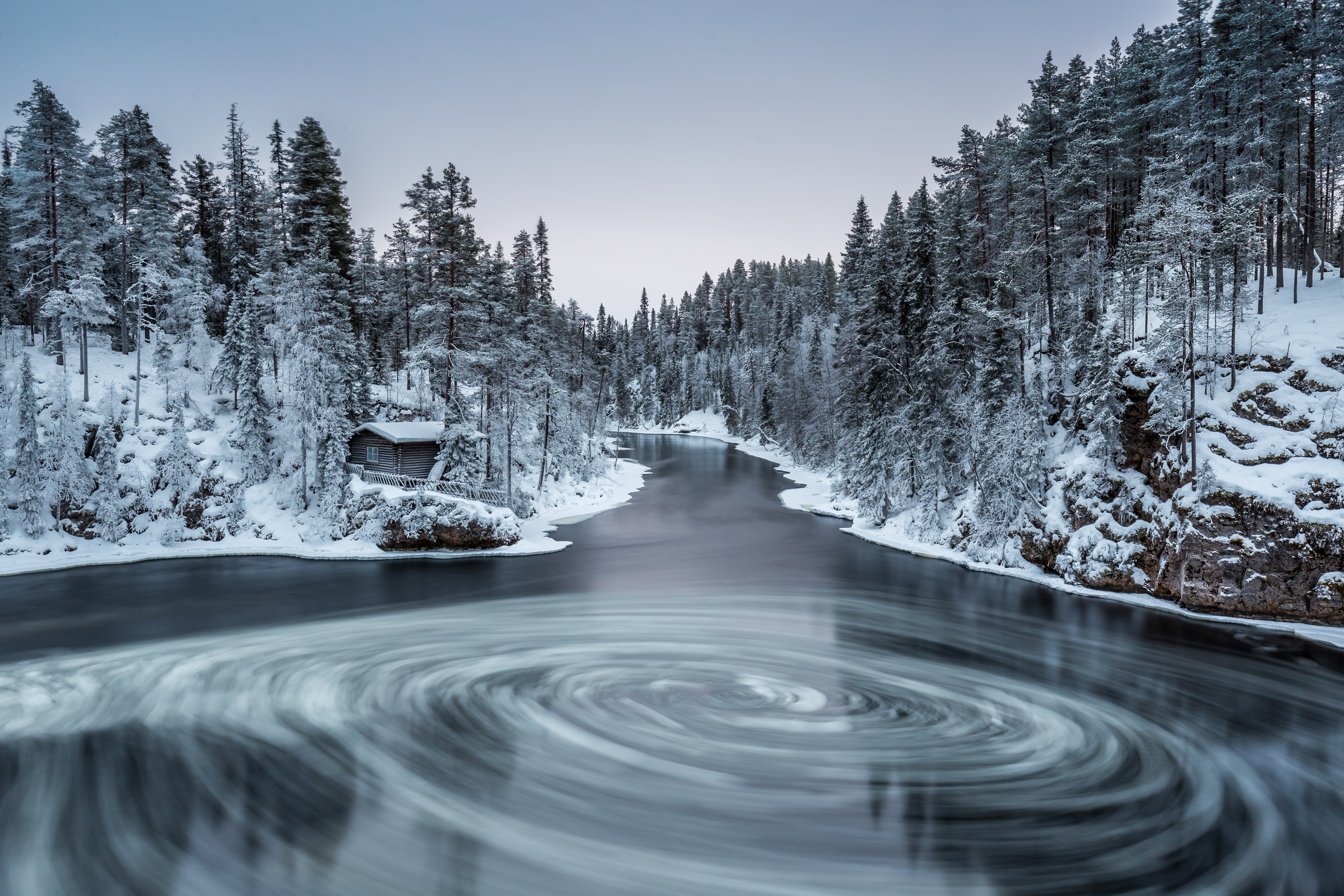 Free photo A whirlpool in a lake with snow banks