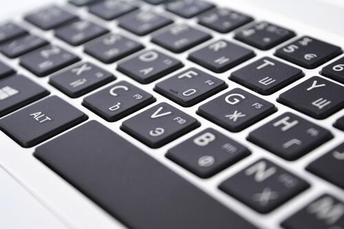 Черные кнопки клавиатуры на белом ноутбуке