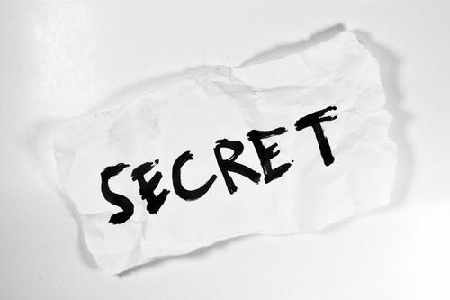 A crumpled piece of paper with the word secret on it