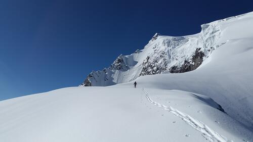 Лыжник взбирается на холм горы