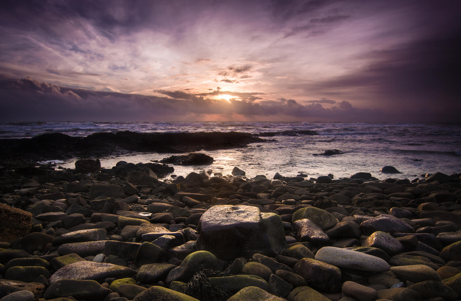 Каменистое побережье моря с восходом солнца