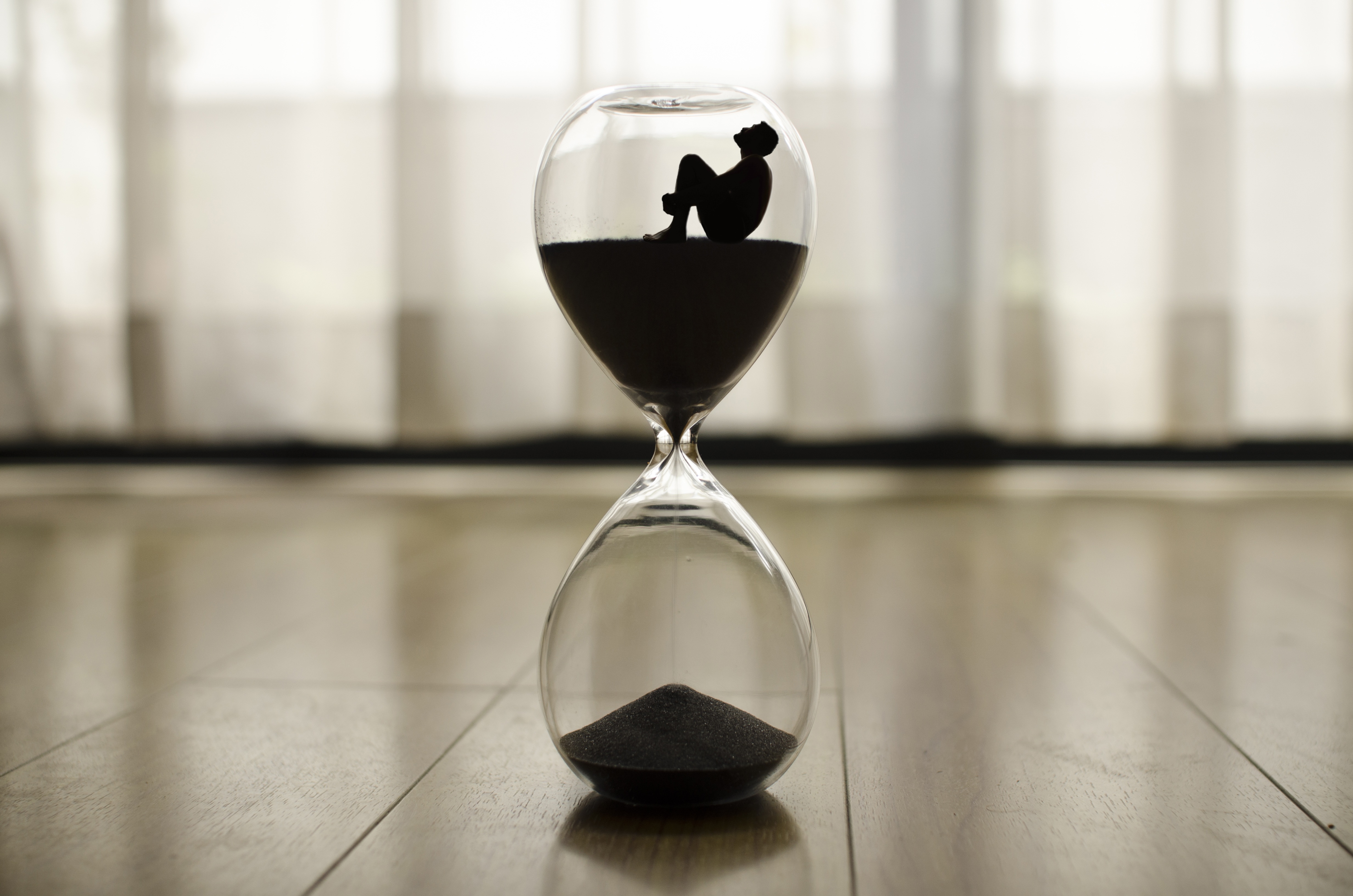 Free photo Creative hourglass with a sitting person