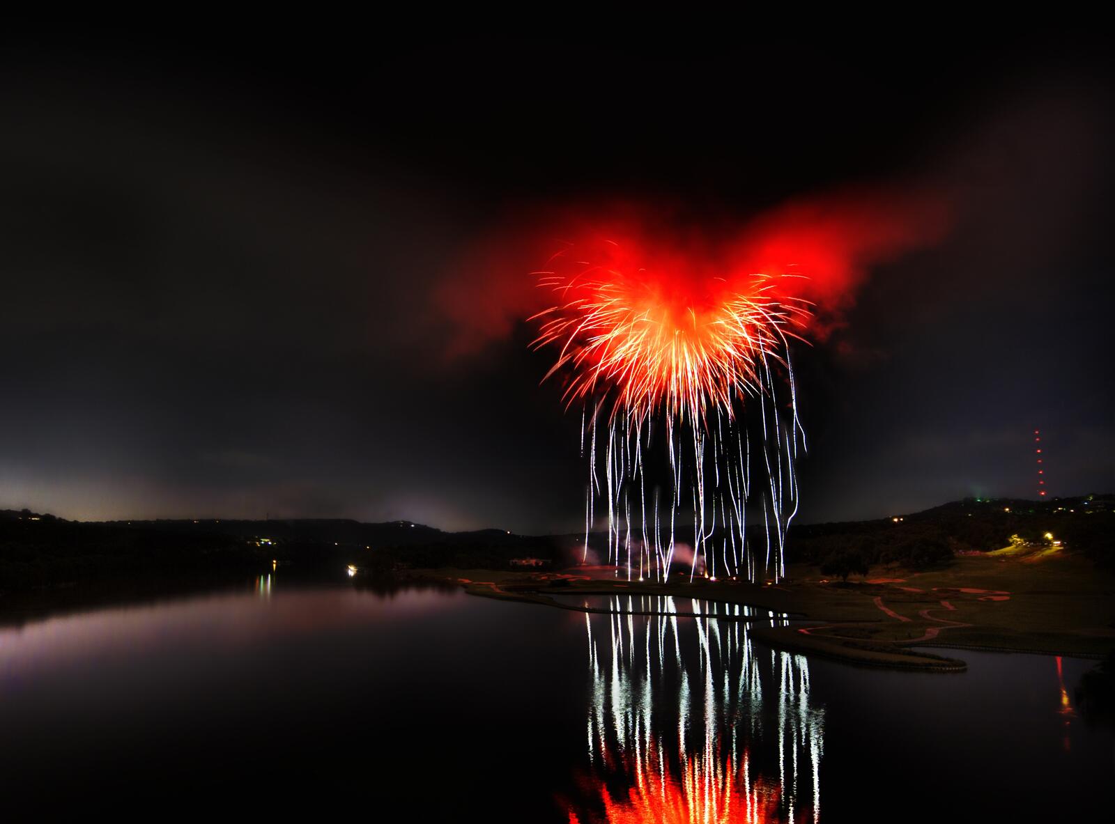 Бесплатное фото Необычный небесный взрыв у реки во тьме