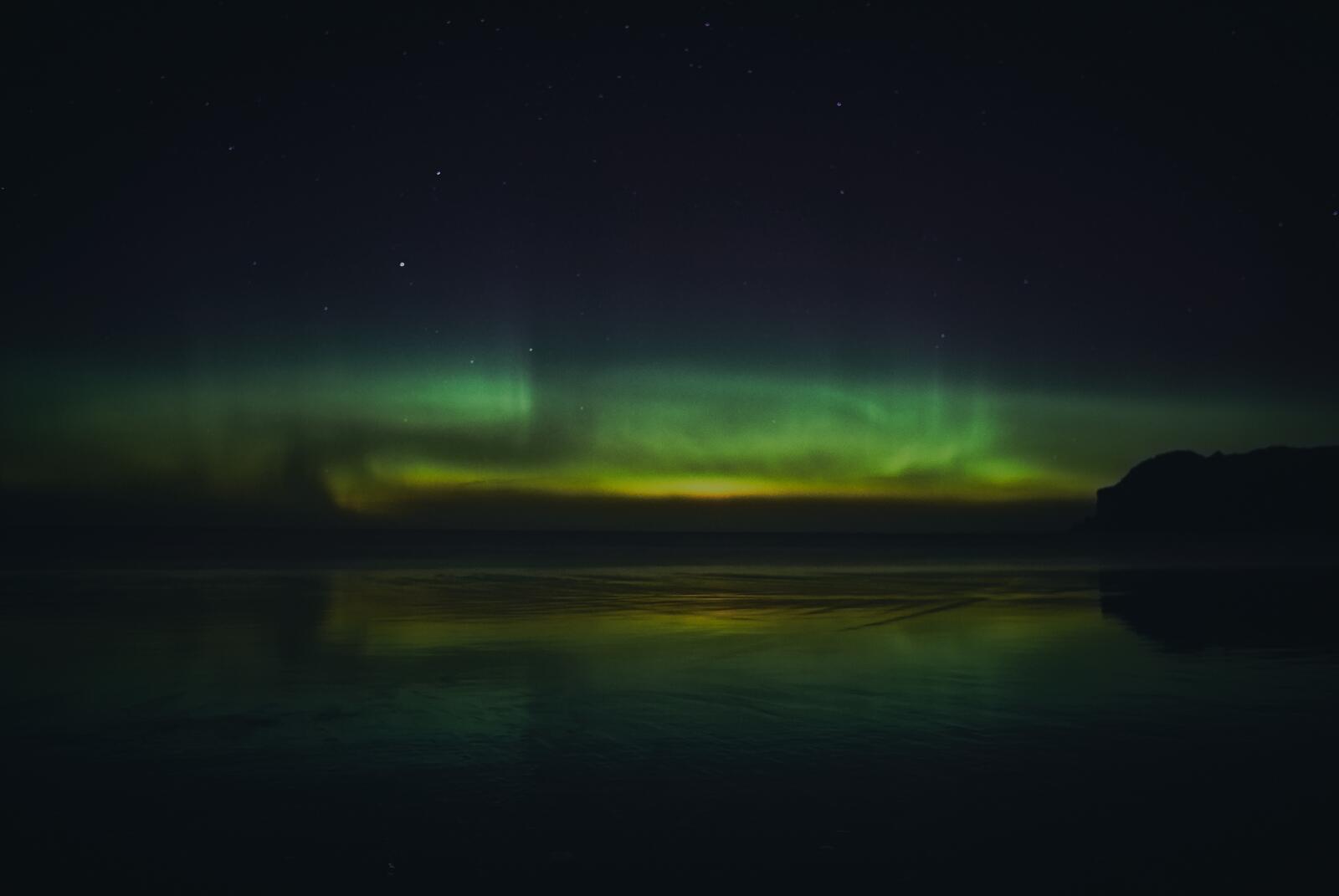 Free photo Nighttime northern lights in the sky over the sea