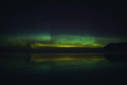 Nighttime northern lights in the sky over the sea
