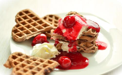 Delicious waffle hearts with cherry jam