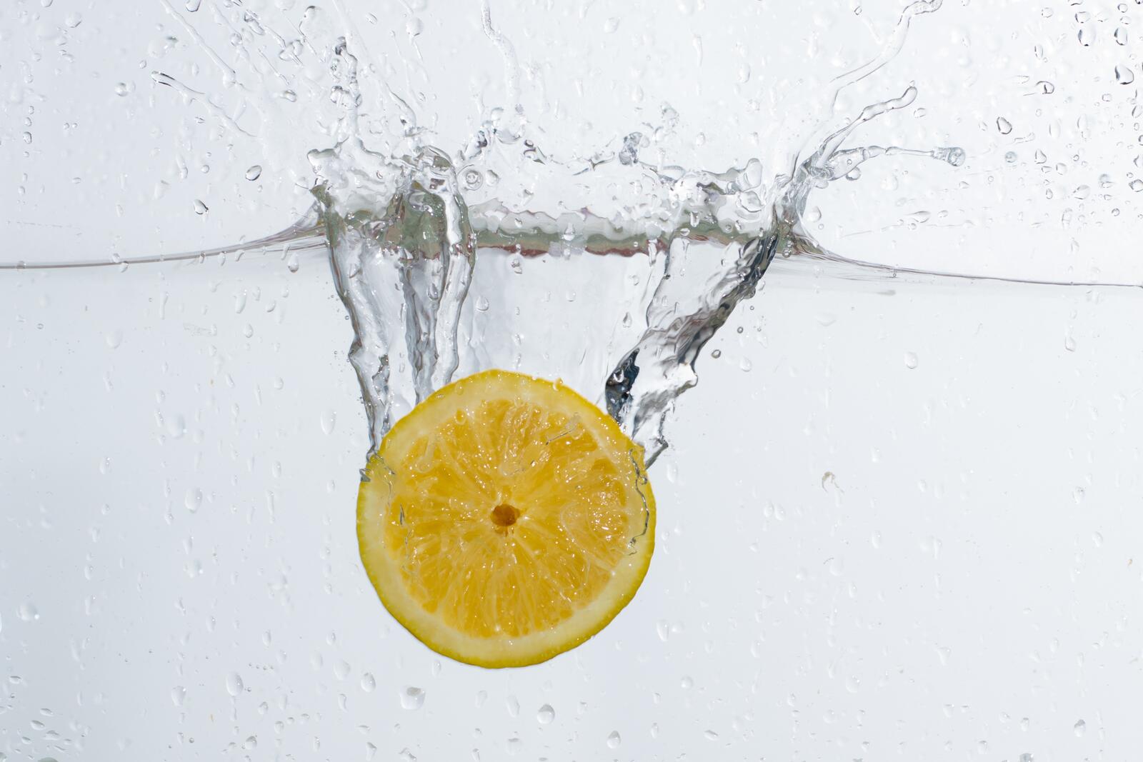 Долька лимона падает в воду