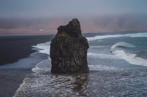 Скала на песочном берегу Исландии