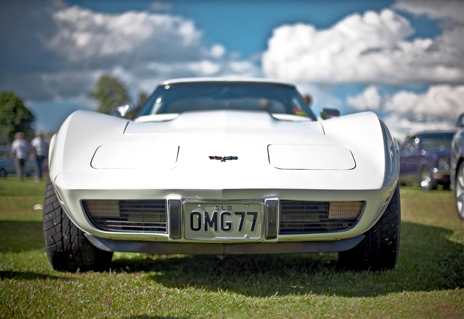 Бесплатное фото Маслкар Corvette со слепыми фарами в белом цвете на автомобильной выставке