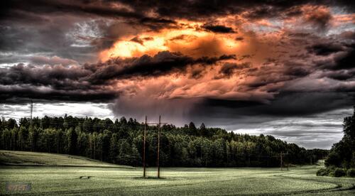A cloud rains down on a green field