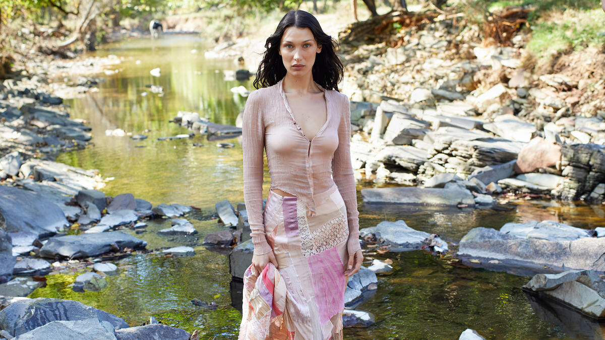Bella Hadid in front of a mountain river