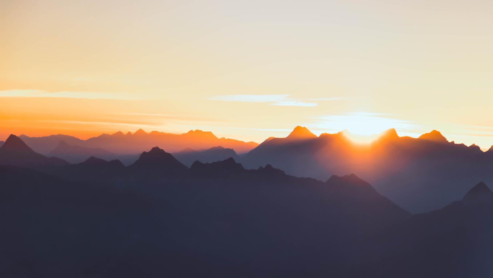 Бесплатное фото Солнце заходит за вершины гор