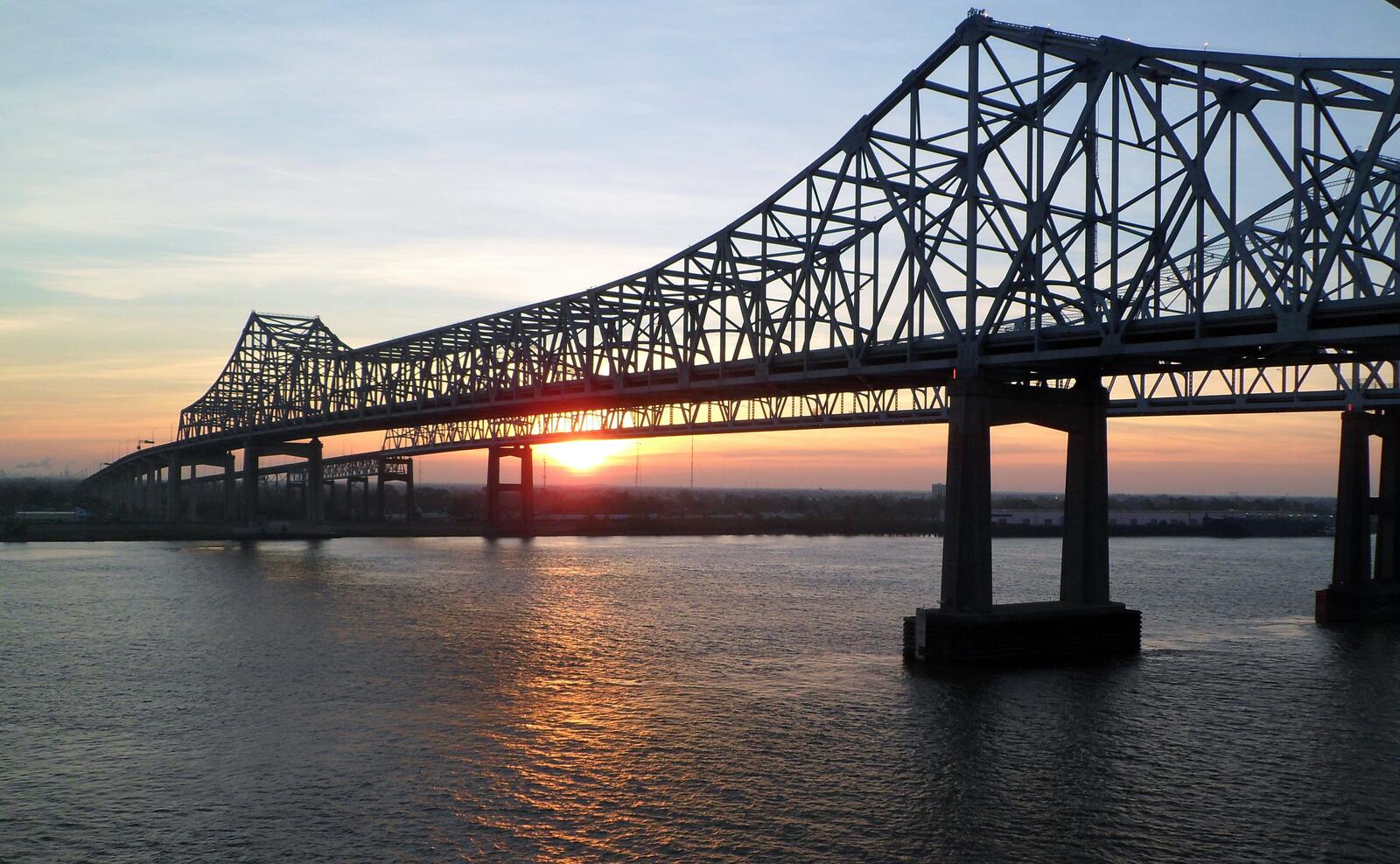 Бесплатное фото Закат солнца на мосту соединяющего два берега залива моря