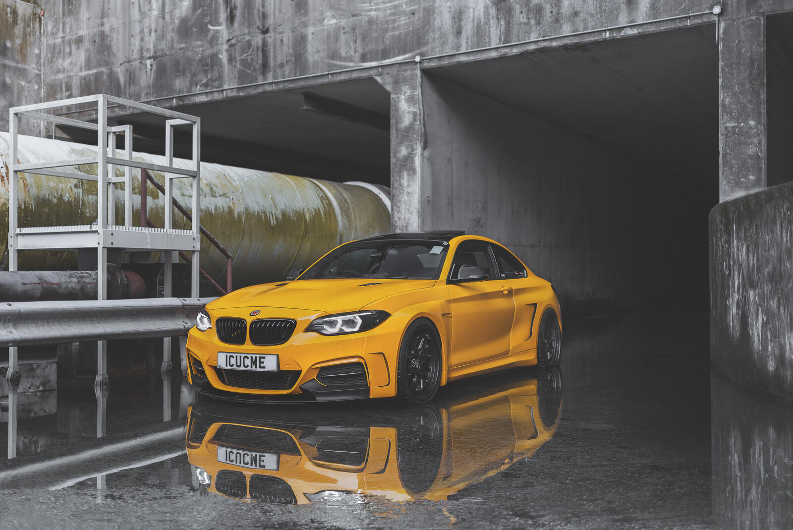 Бесплатное фото BMW M2 в желтом цвете отражается в луже