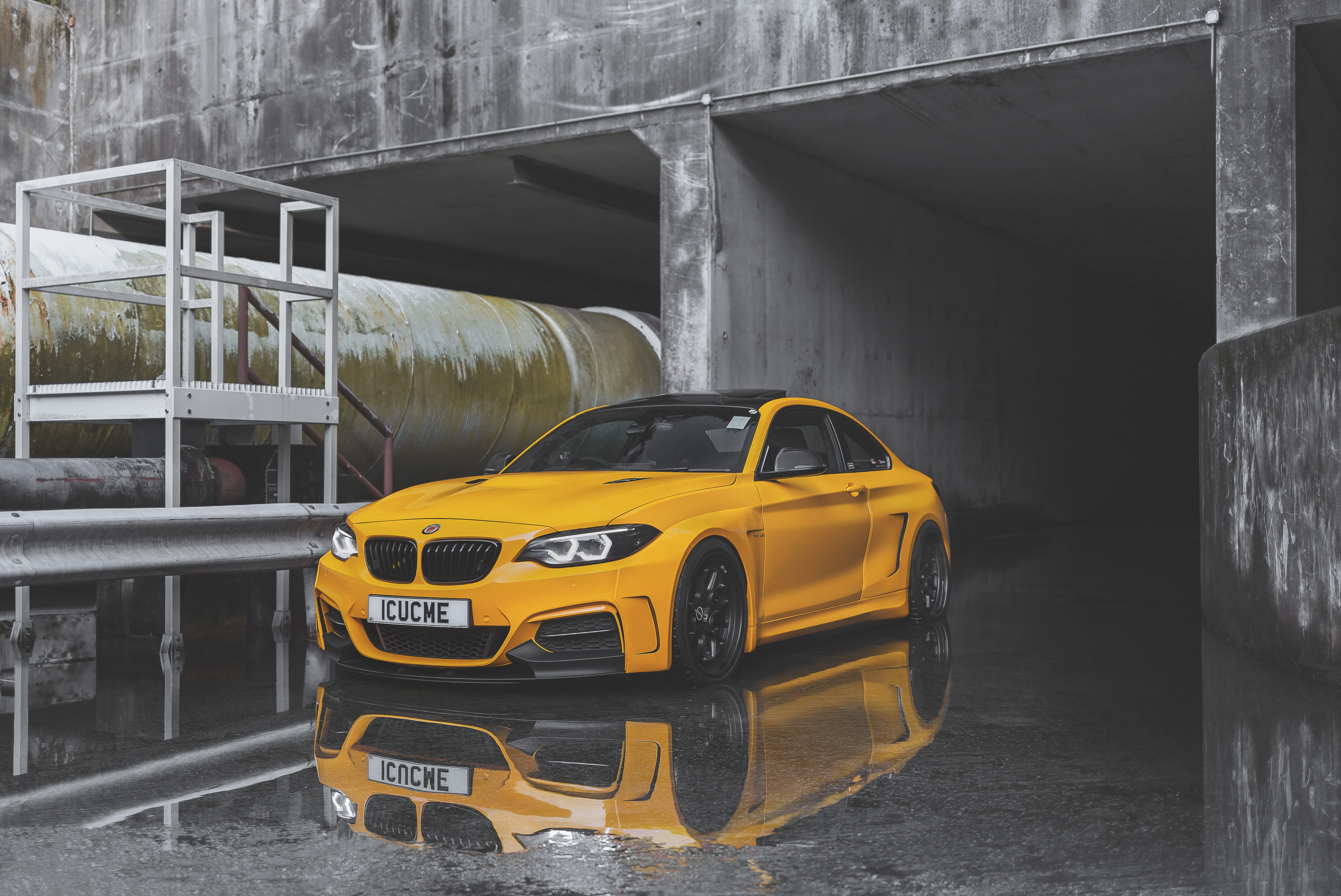 BMW M2 в желтом цвете отражается в луже