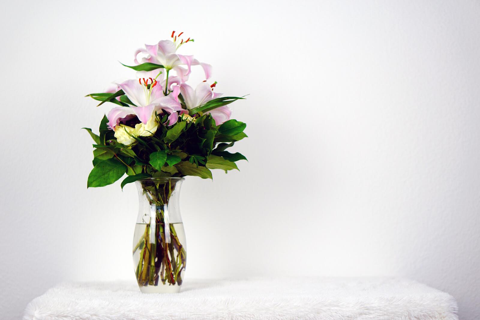Free photo Transparent vase with ikebana flowers