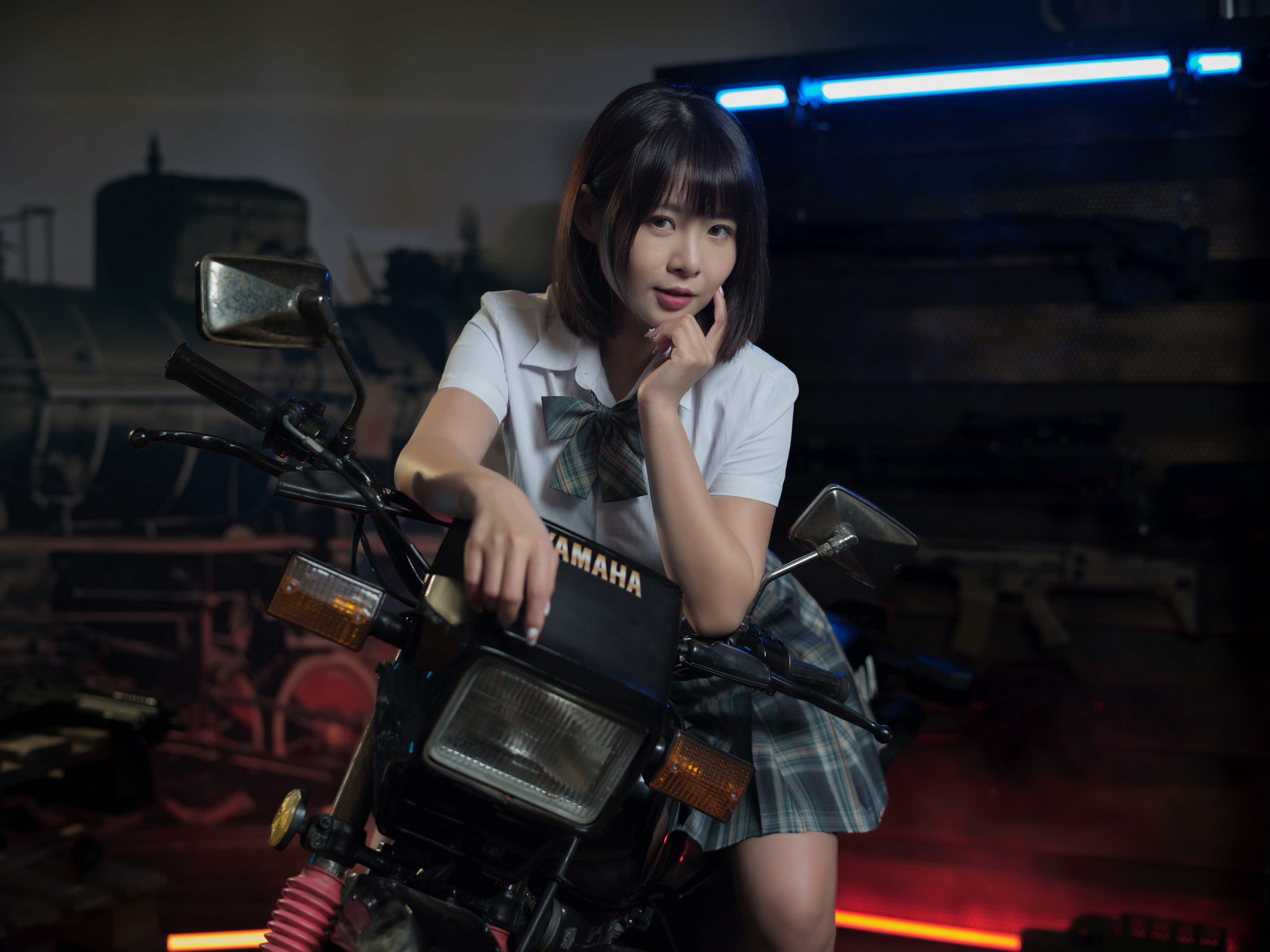 Молодая азиатка сидит на мотоцикле
