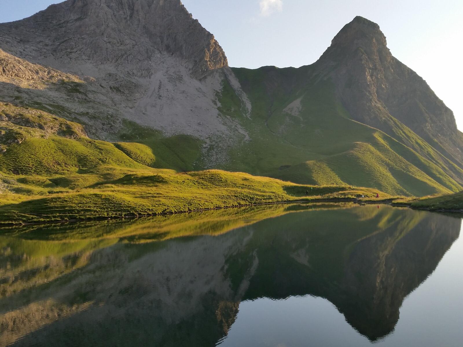 免费照片丘陵地区的一个湖泊，绿草如茵