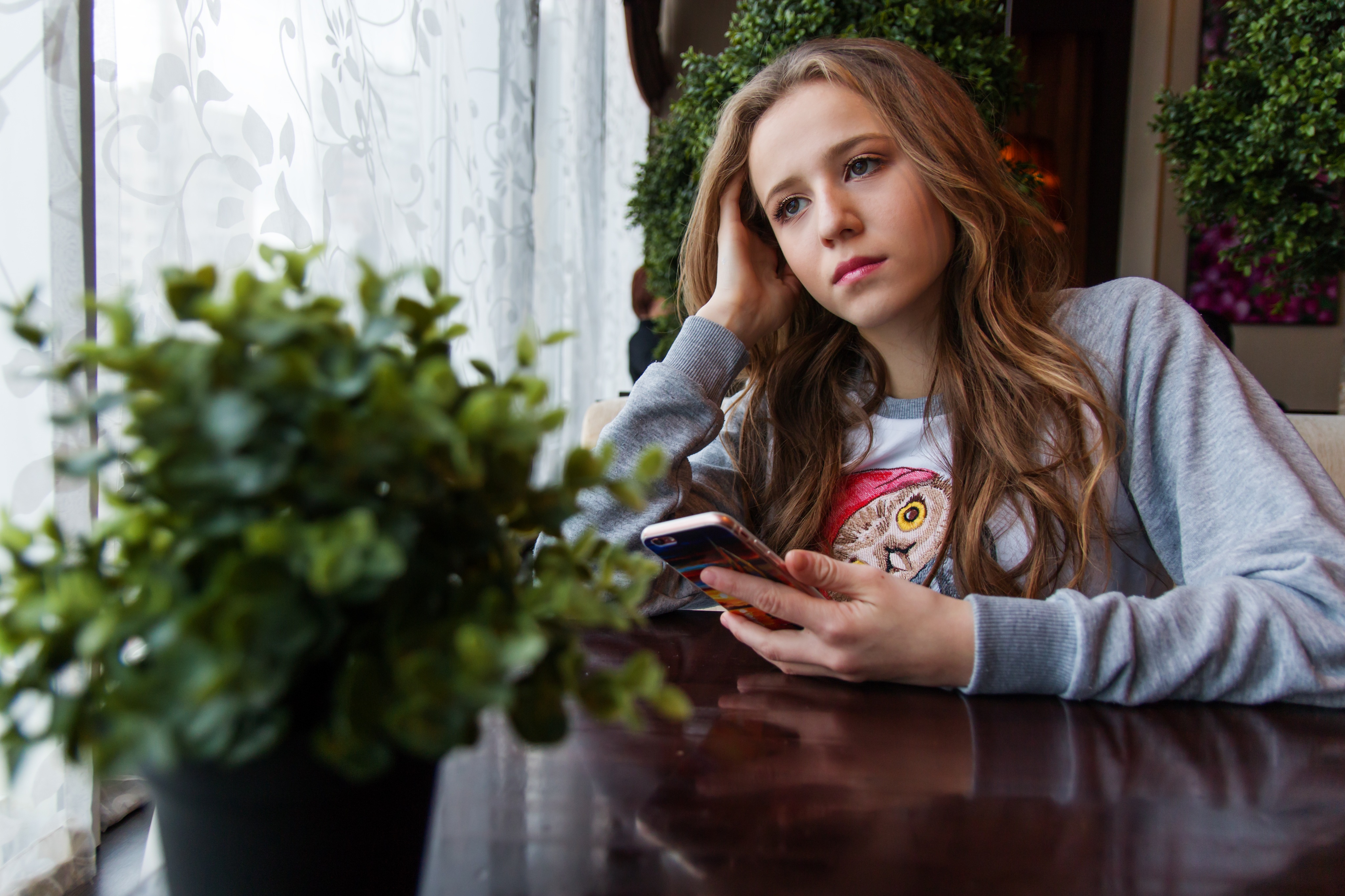 Бесплатное фото Задумавшаяся девочка сидит в кафе