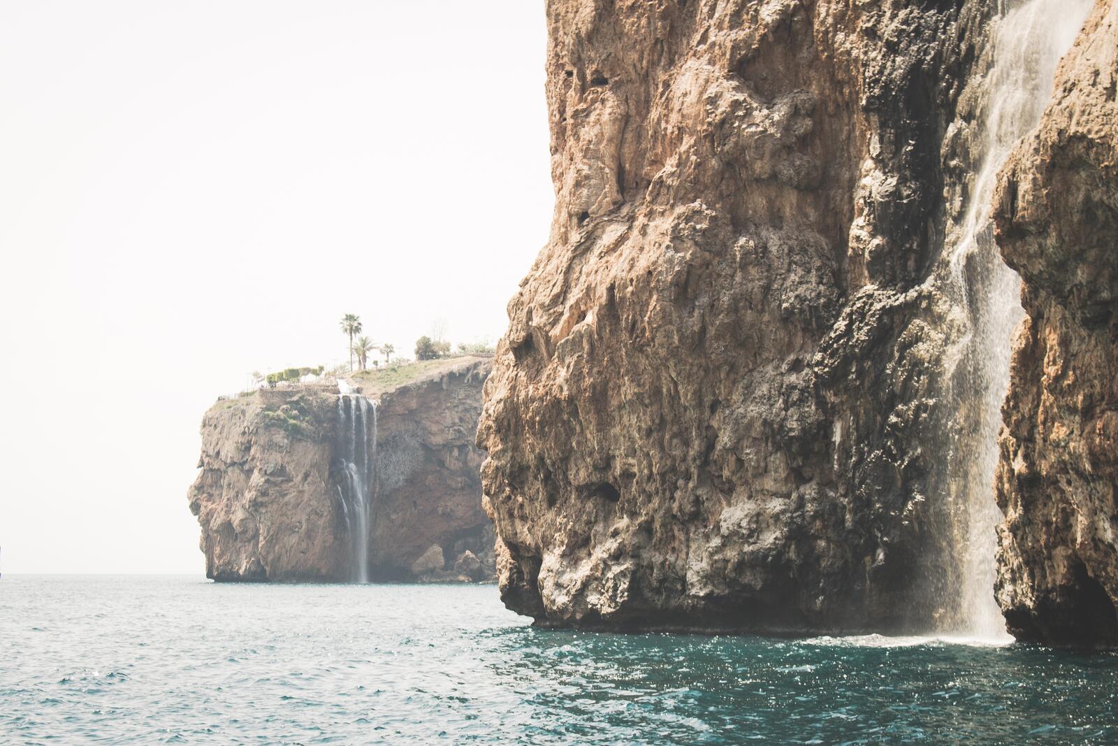 免费照片一块高大的岩石上有一个瀑布