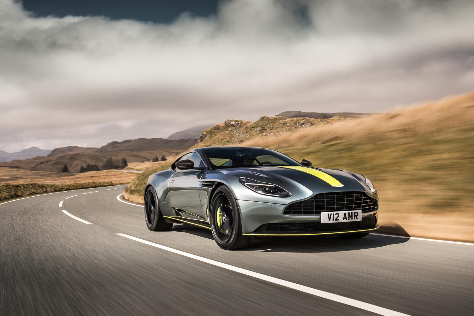Free photo Aston Martin DB11 driving down a country road.