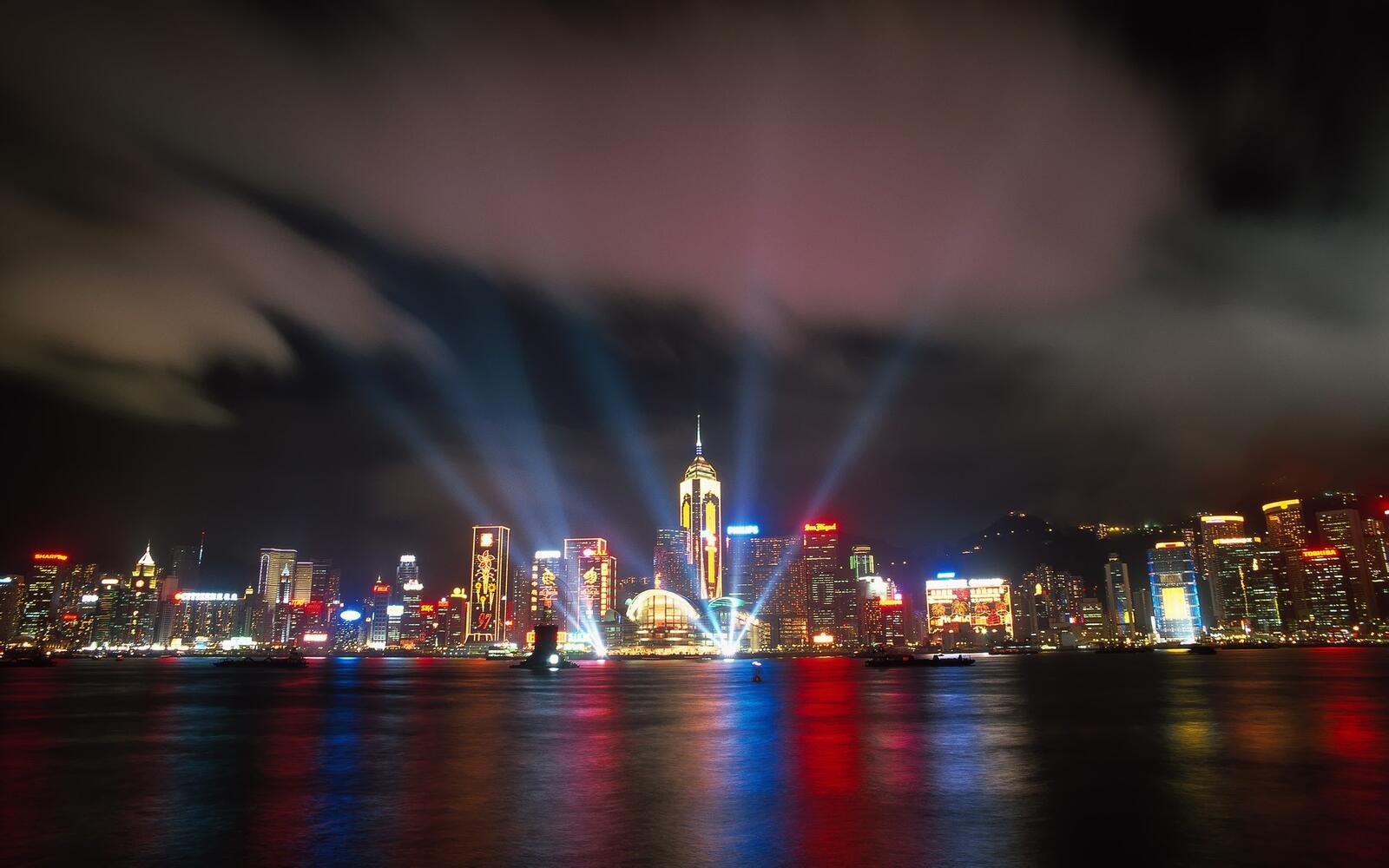 Бесплатное фото Лазерные лучи направленные в небо у ночного города
