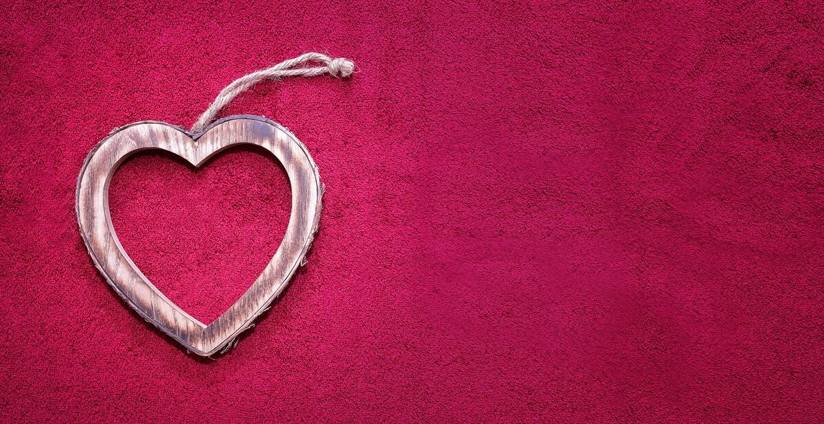 Деревянный брелок в виде сердца на розовом фоне