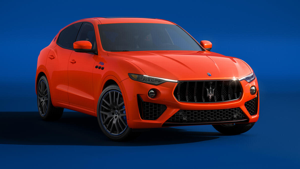 Оранжевый Maserati Levante Ftributo 2022 года выпуска на синем фоне
