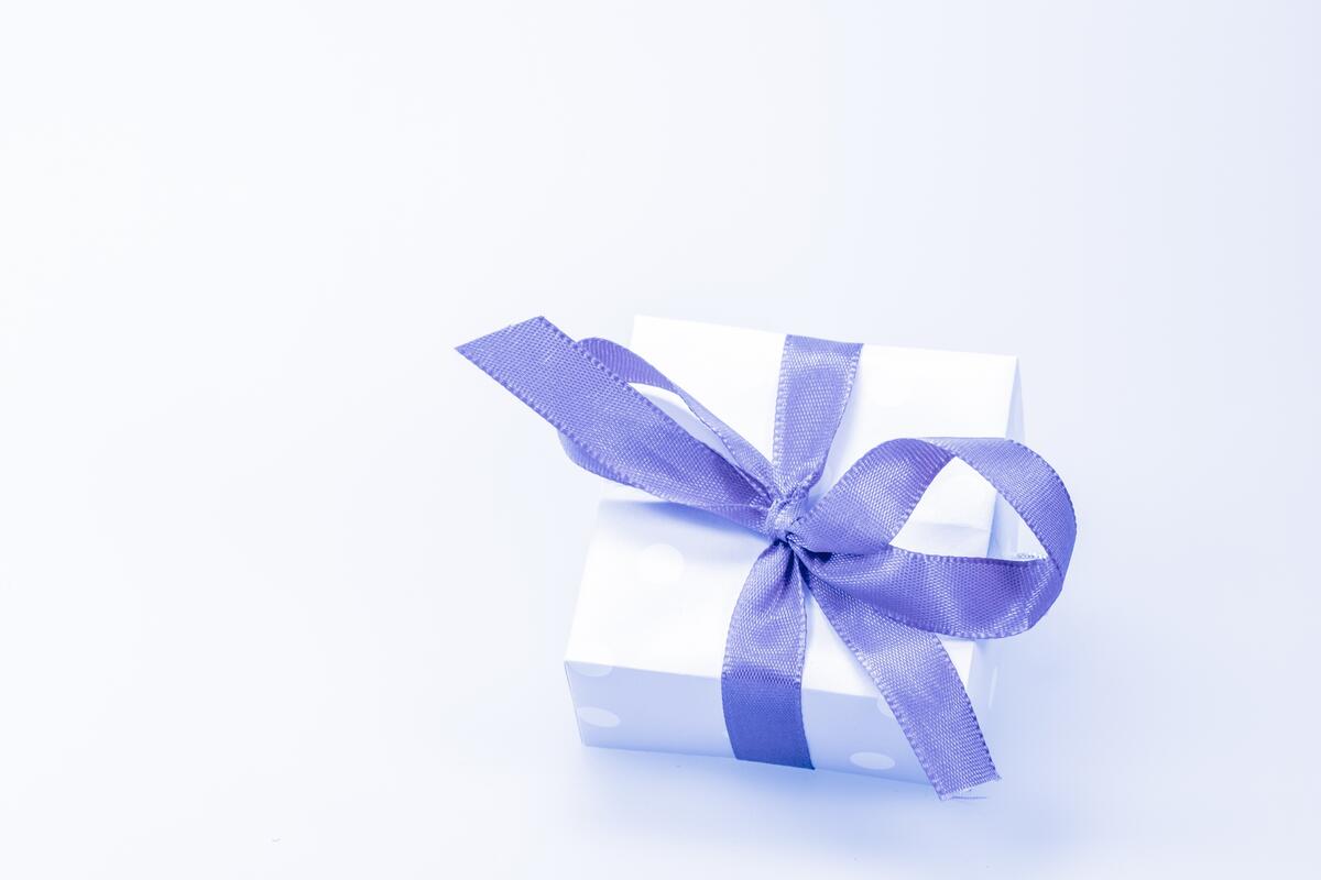 Подарочная коробка с фиолетовый бантиком на голубом фоне