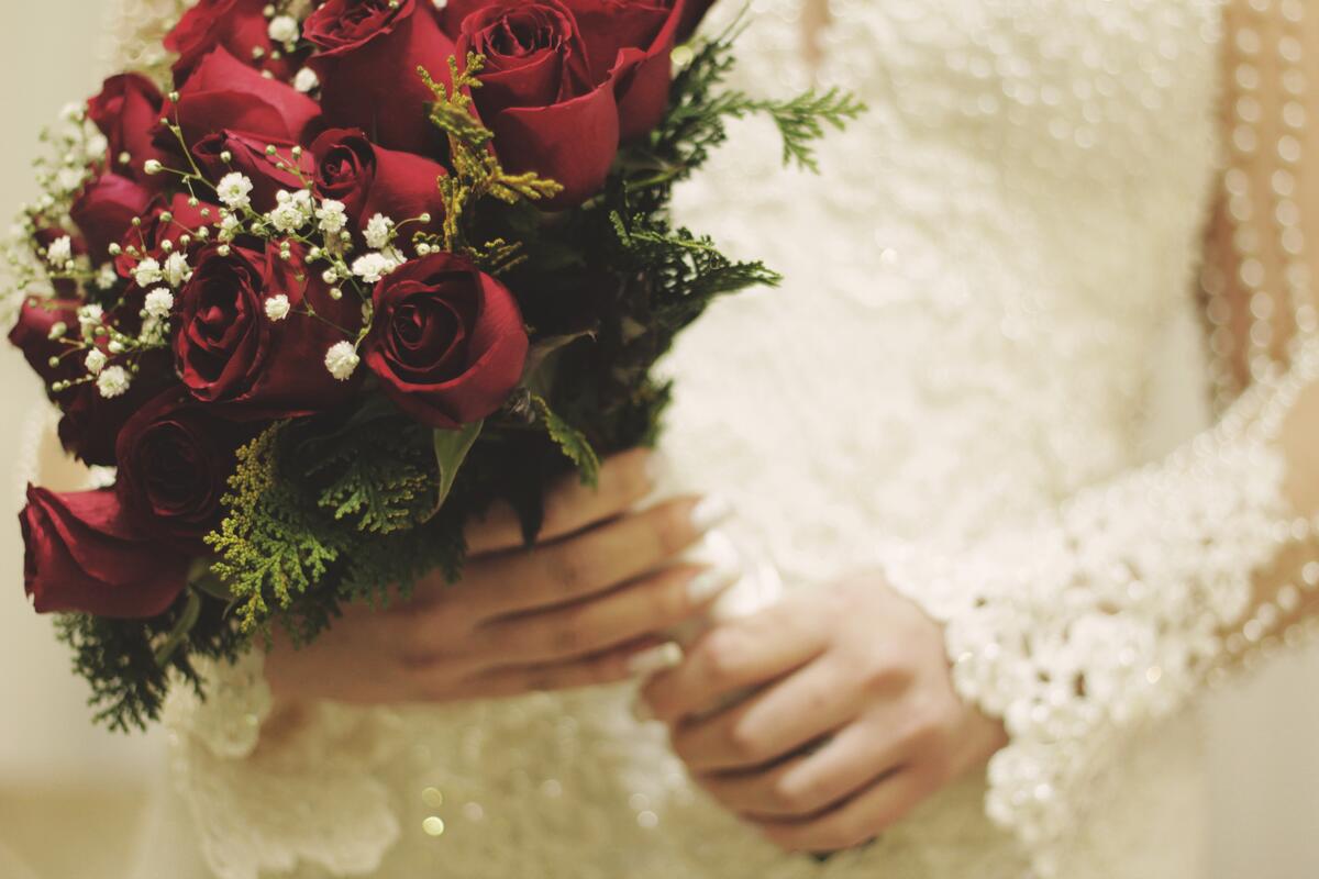 A bride with a bouquet of red roses