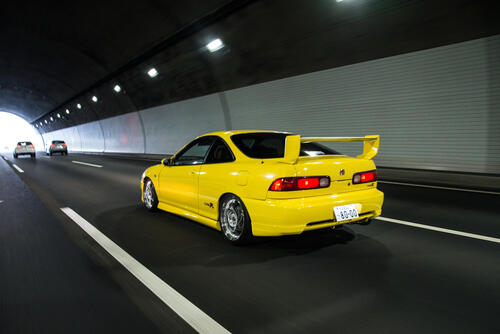 Yellow acura integra driving through the tunnel.