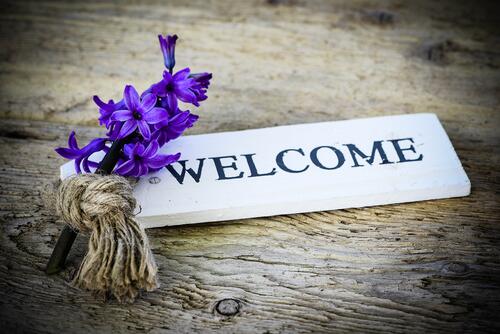 Welcome sign with a purple flower