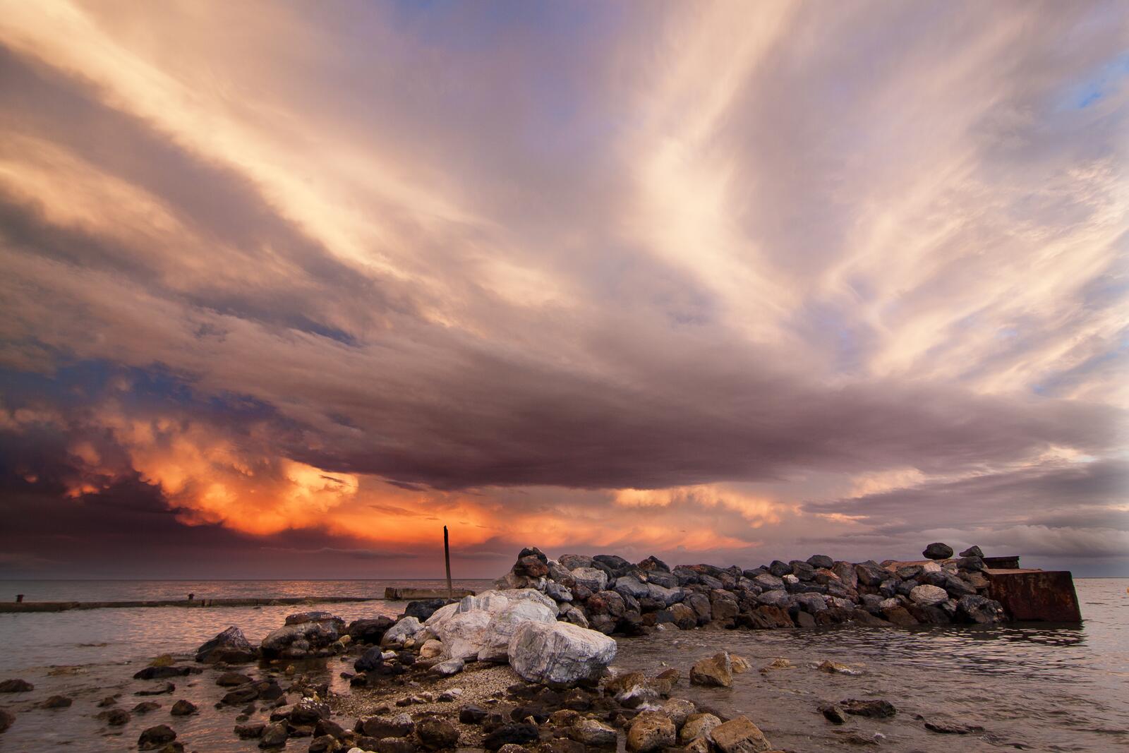 Бесплатное фото Каменистая дамба возле берега моря в сумрачный вечер