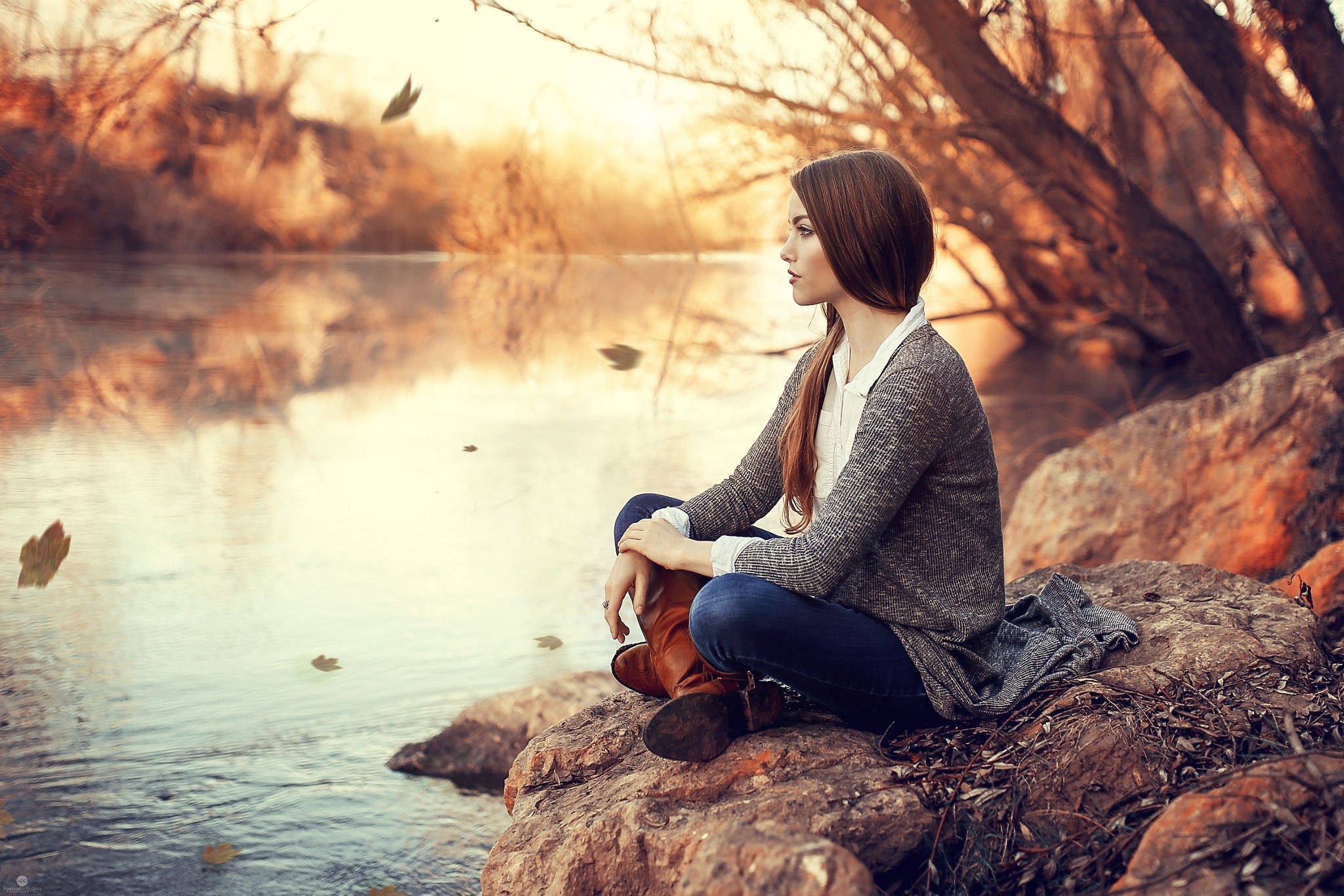 免费照片黑发女子坐在水边，向远处眺望。