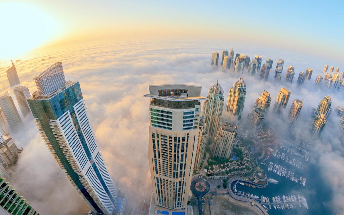 Городские небоскребы в облаках вид сверху