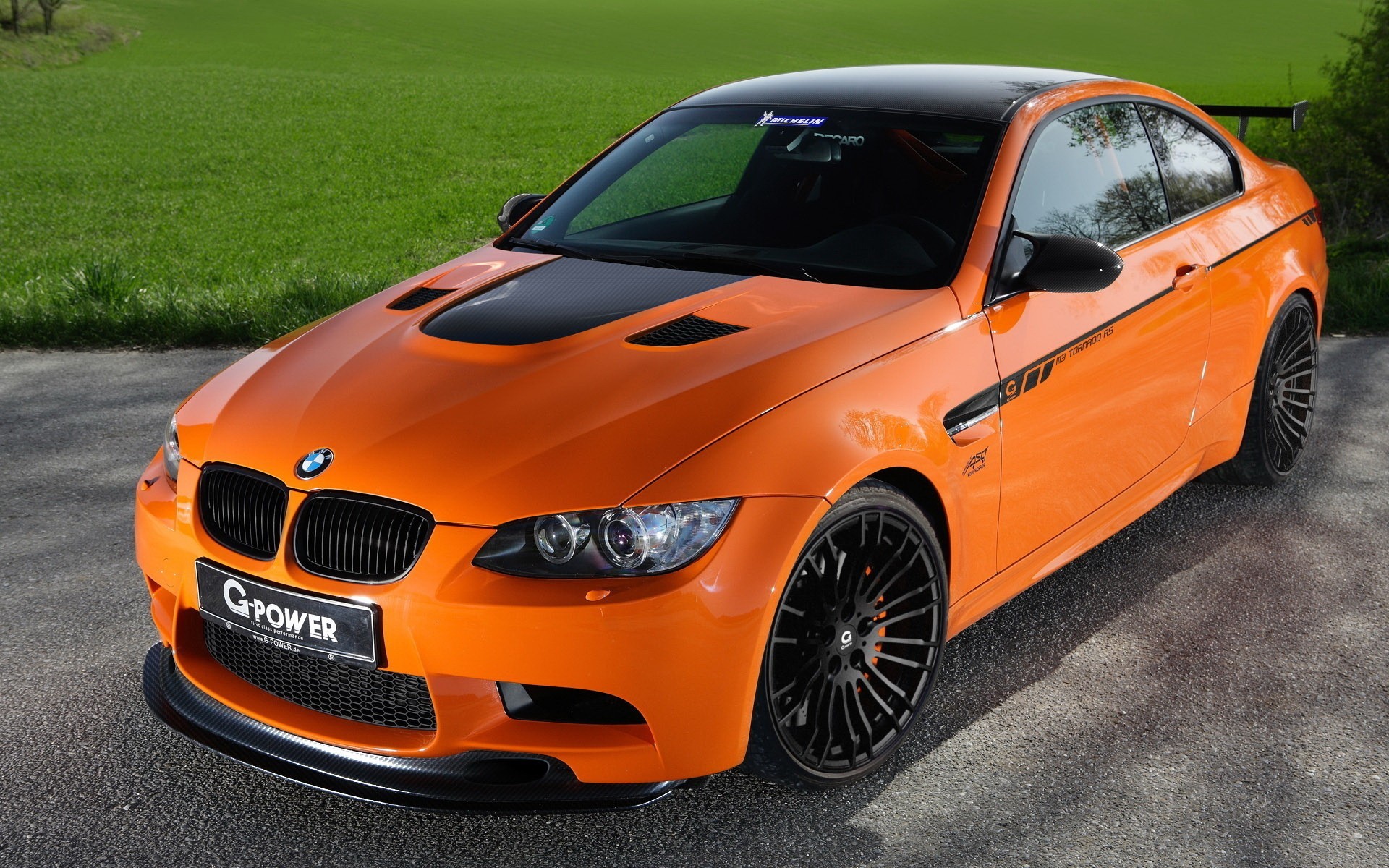 Бесплатное фото Оранжевая BMW M3 на черных альпинах